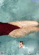 A woman in a red bikini laying in the water.