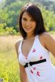 A woman in a white tank top posing for a picture.