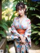 A woman in a blue and orange kimono posing for a picture.