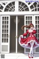 A woman in a red and white dress standing in front of a door.