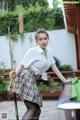 A woman in a skirt and shirt is playing pool.