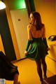 A woman in a green dress standing in a room.